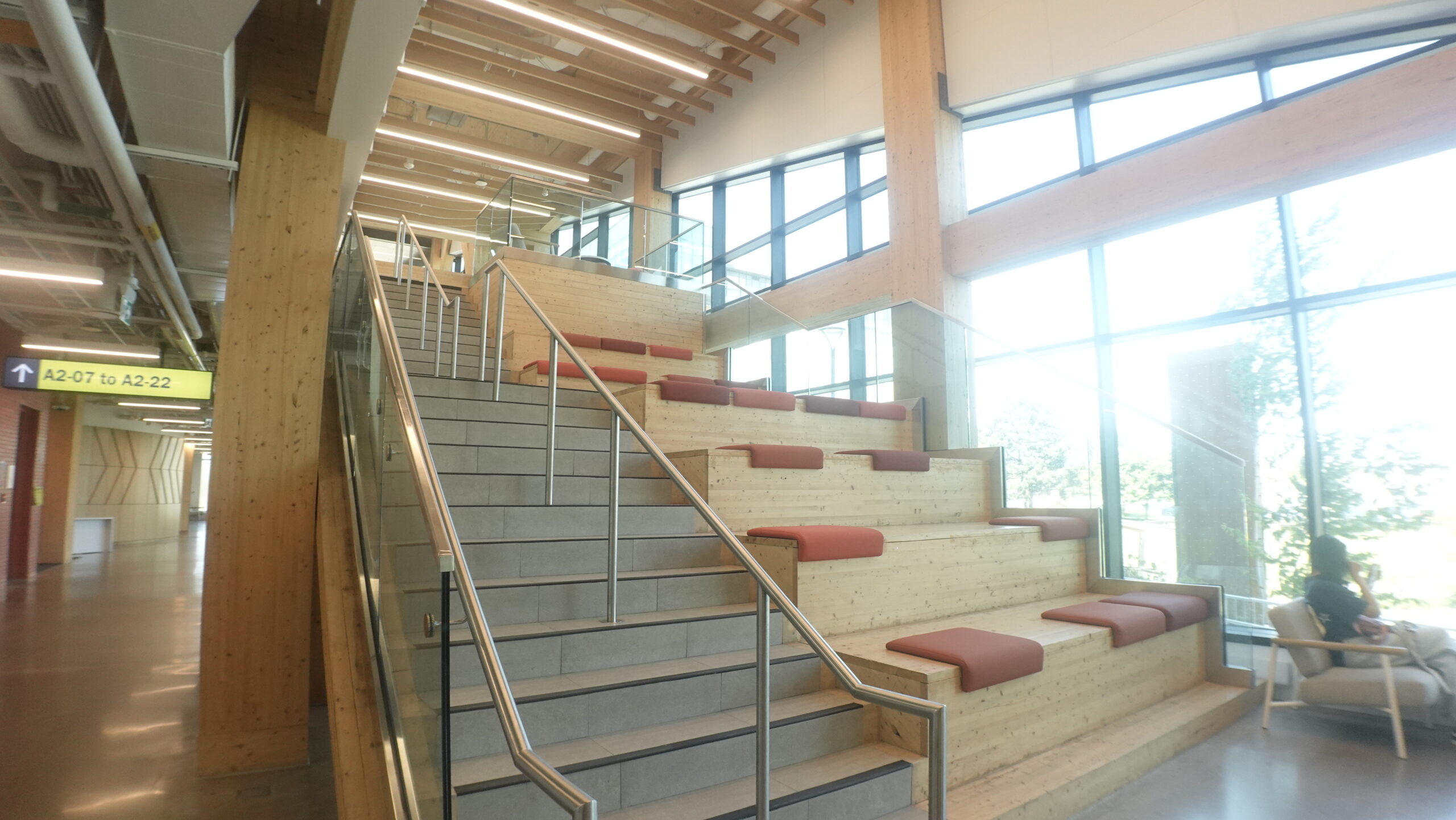 Grand atrium staircase and tiered wooden student seating at Centennial College